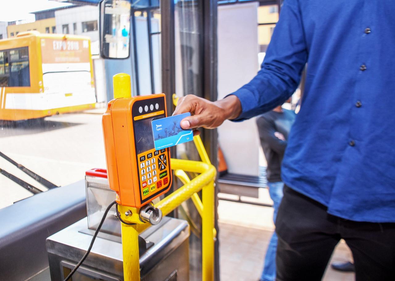 A passenger tapping an AC Mobility card on a public bus